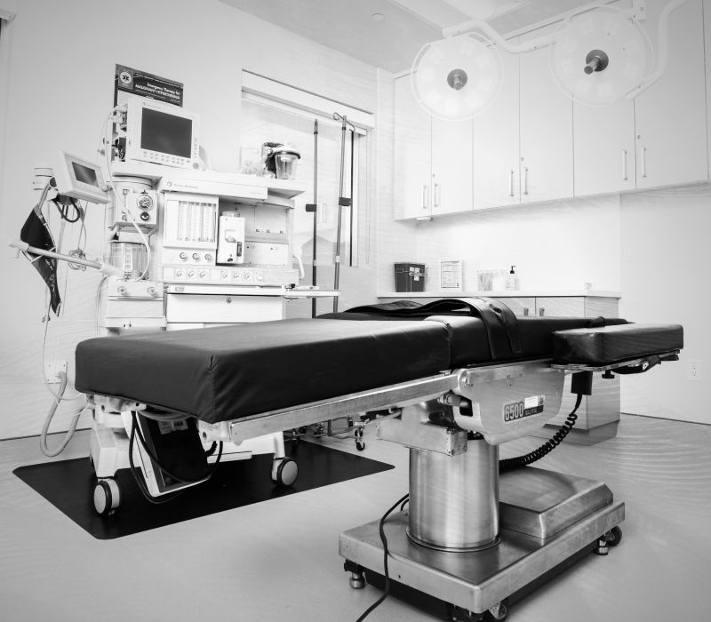 Modern surgical room with equipment and operating table.