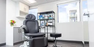 Modern aesthetic treatment room with chair and supplies.