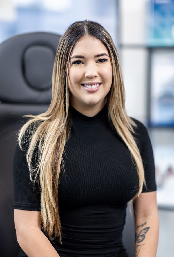 Smiling woman in black attire indoors.