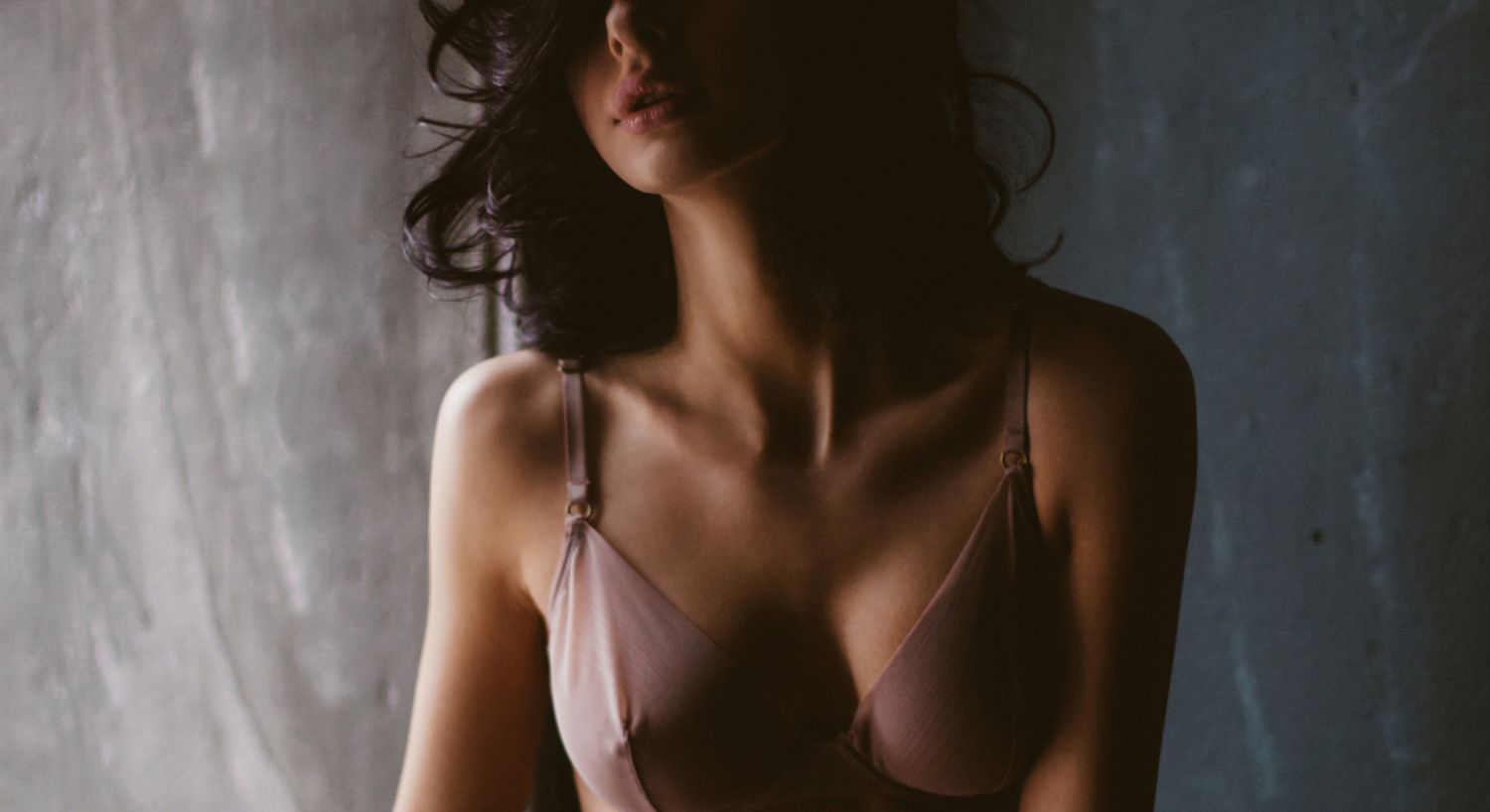 Woman in a bra with soft, ambient lighting.