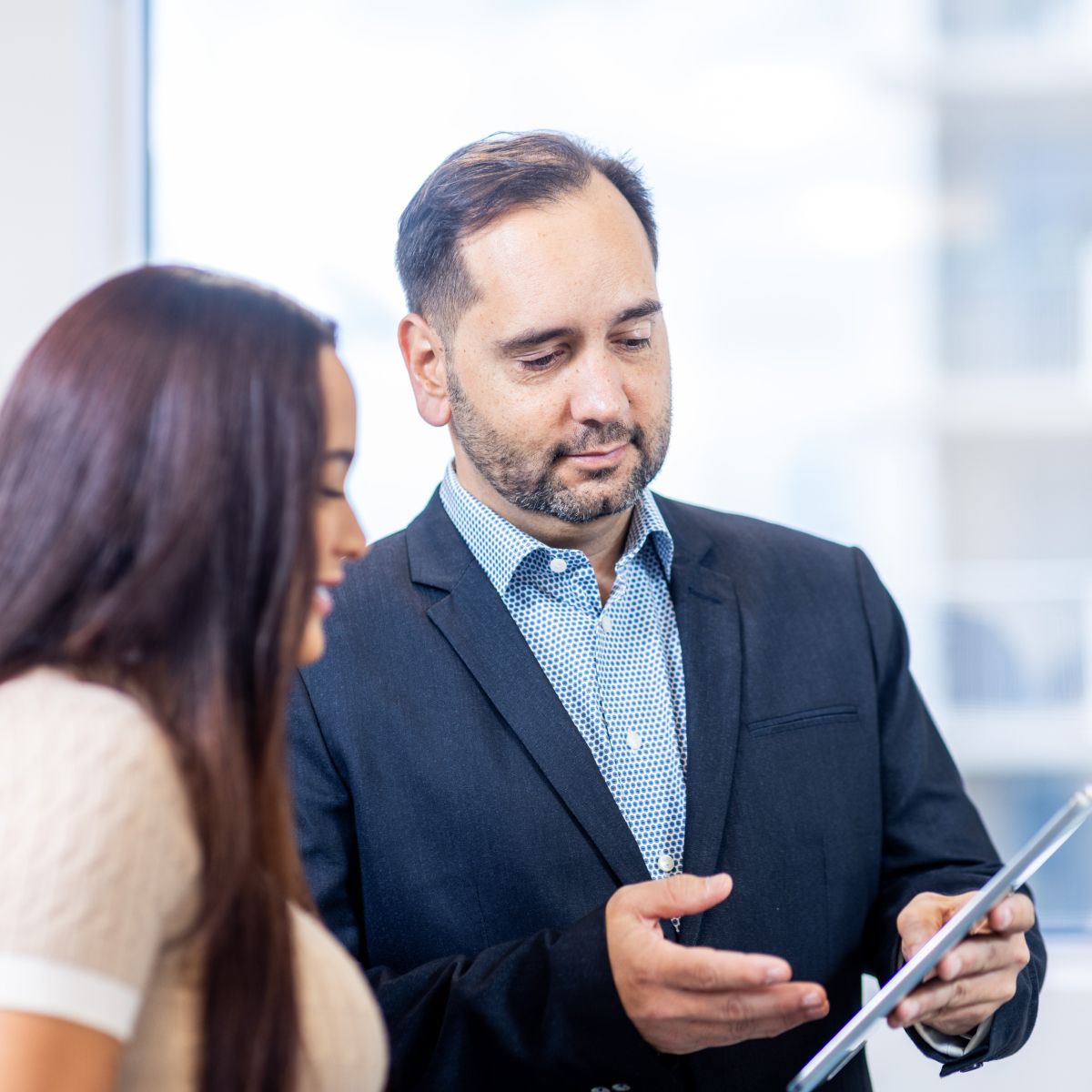 Business colleagues discussing information on a tablet.