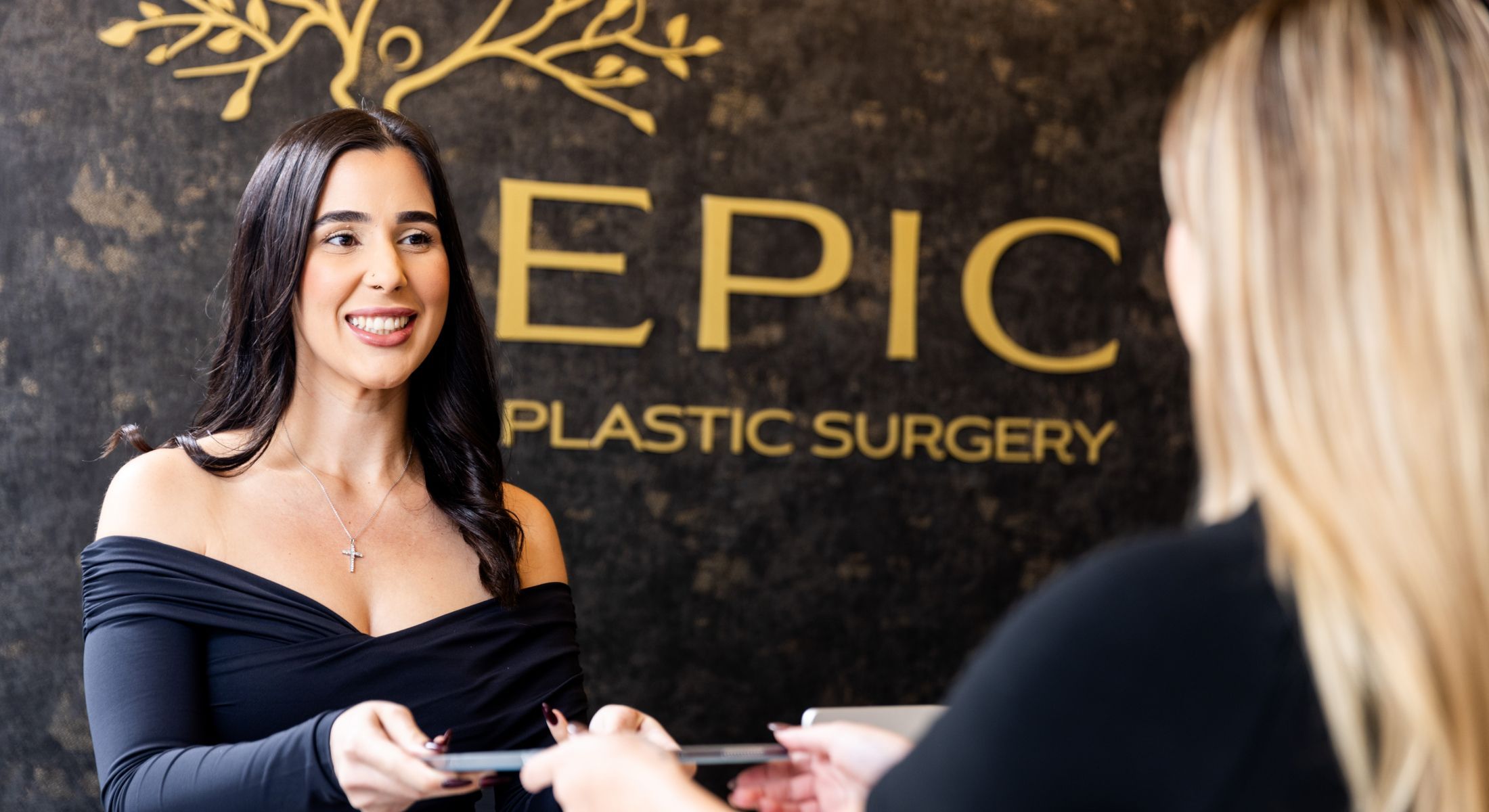 Receptionist at Epic Plastic Surgery office smiling.