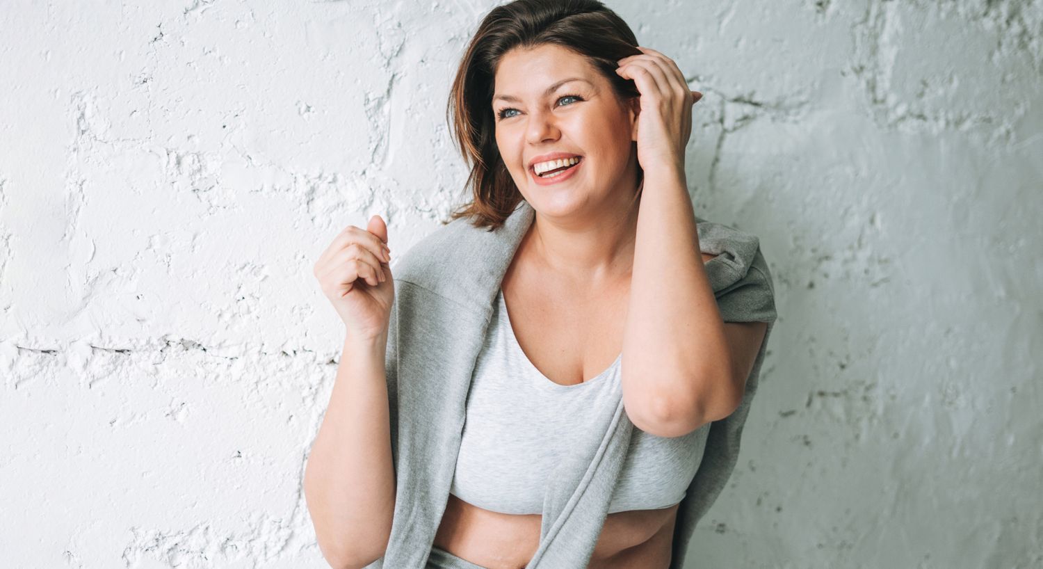 Smiling woman with short hair in gray attire.