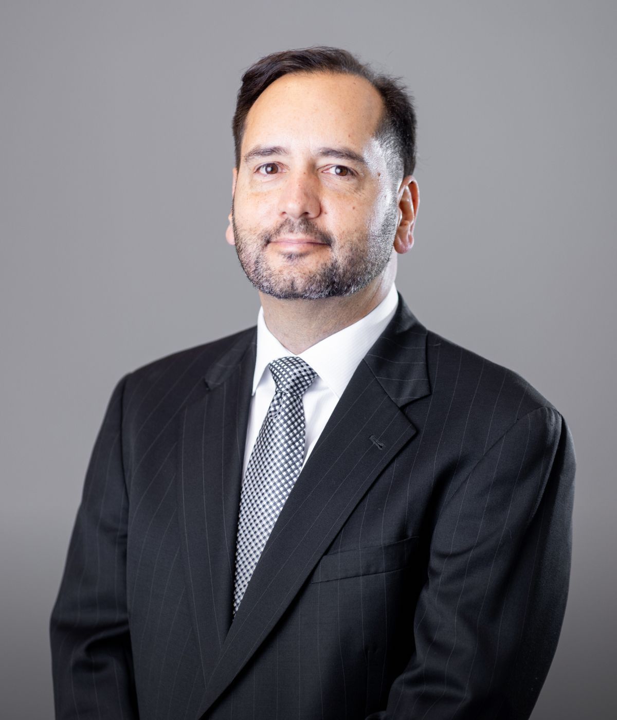 Man in a suit against a gray background.