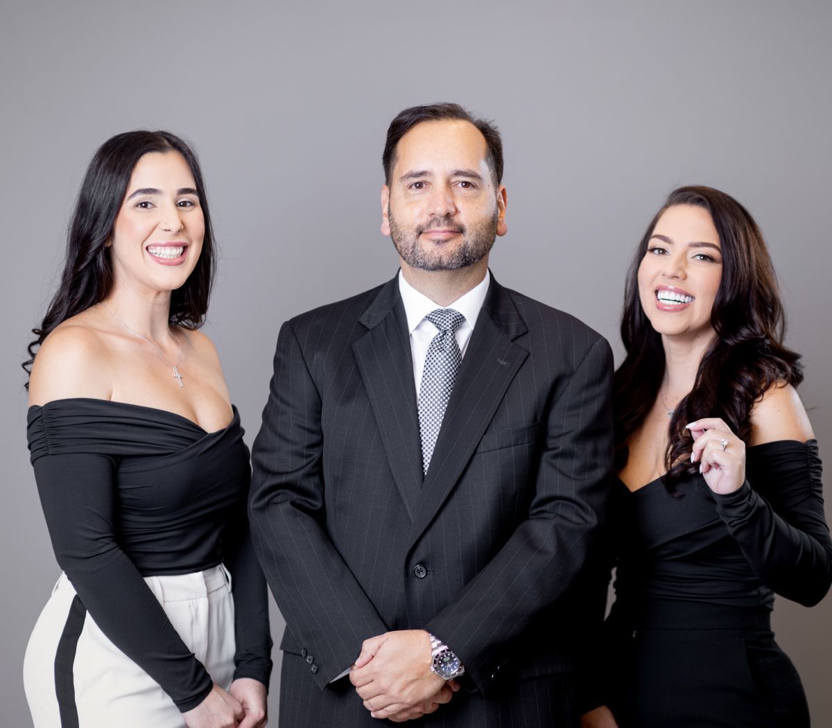 Three professionals posing confidently in formal attire.